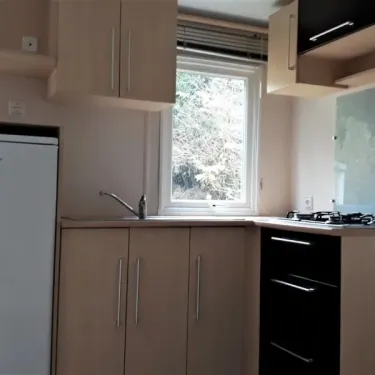 Cuisine équipée avec réfrigérateur, plancha et fenêtre - MH Eco 3CH - Camping Les Rives d'Olt et d'Aubrac