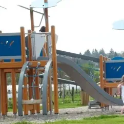 Enfants jouent sur une aire de jeux extérieure au Camping Paradis Vallée du Lot.