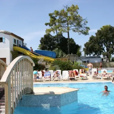 Piscine extérieure avec toboggan jaune et personnes se relaxant sur des chaises longues, Camping Zagarella.