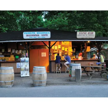 Bar à vin et dégustation au Camping Eurolac avec des tonneaux en bois.