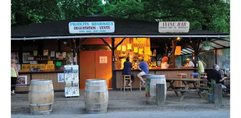 Bar à vin et dégustation au Camping Eurolac avec des tonneaux en bois.
