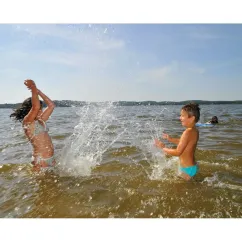 Enfants qui jouent dans l'eau d'un lac au Camping Eurolac.