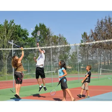 Famille qui joue au badminton sur une cour intérieure à Camping Eurolac.