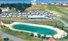 Vue aérienne du camping avec piscine ovale et cabanes autour