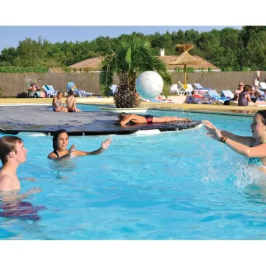 Personnes dans une piscine à Camping Eurolac, jouant avec un ballon sous l'eau.