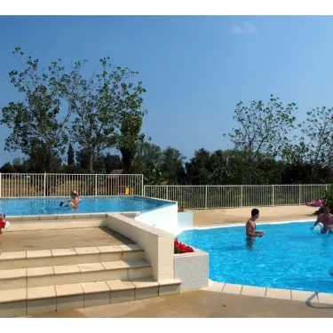 Personnes qui se baignent dans une piscine extérieure à Camping Les Fontaines
