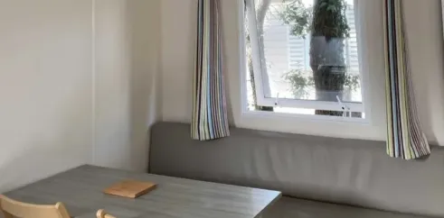 Mobil Home Primeo S 2CH - Camping Les Sables d'Argent : coin repas avec banc et table