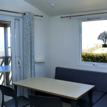 Intérieur Mobil Home Ophea S 2CH - 4/6P - Camping Les Sables d'Argent avec table et canapé