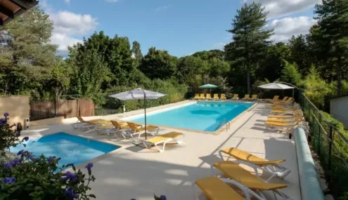 Piscine avec chaises longues jaunes et parasols au Camping de la Colombière