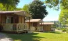 Camping Le Bourdieu - cabanes en bois avec balcons en bois clair sur pelouse verte