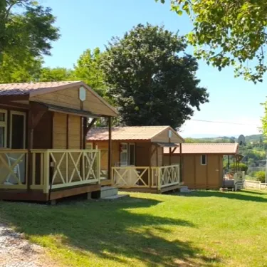 Camping Le Bourdieu - cabanes en bois avec balcons en bois clair sur pelouse verte