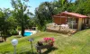 Cabane en bois avec balcon et jardin fleuri près de la piscine au Camping Le Bourdieu