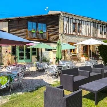 Camping Le Bourdieu - terrasse extérieure avec parasols, tables et chaises en métal