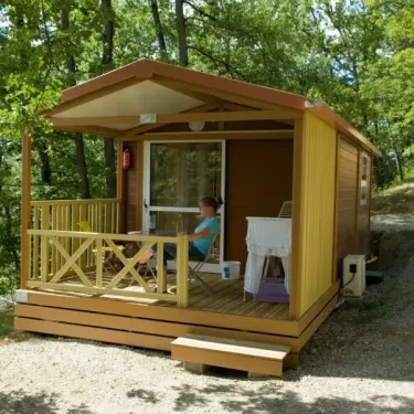 Cottage Duo 2P - Camping Le Bourdieu : cabane en bois avec balcon et table