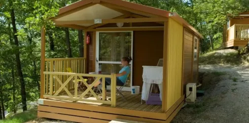 Cottage Duo 2P - Camping Le Bourdieu : cabane en bois avec balcon et table