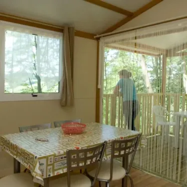 Cottage 2CH - 5P - Camping Le Bourdieu : salle à manger avec table et chaises