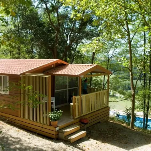 Cottage 2CH - 5P - Camping Le Bourdieu : extérieur avec véranda et piscine