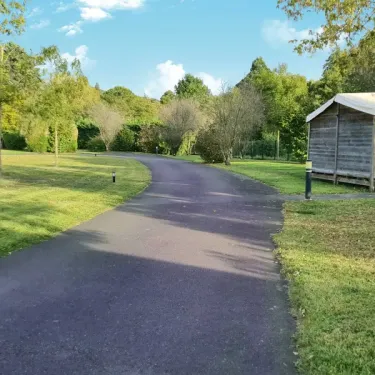 Allée pavée menant à une cabane en bois au camping Val de Braye