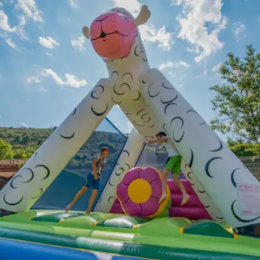 Enfants sur un manège en forme de mouton au Camping La Cascade