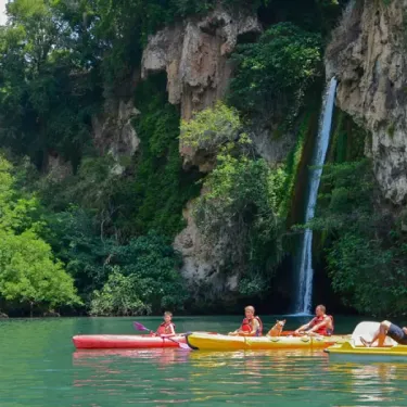 Kayak sur un lac près d'une cascade au Camping La Cascade