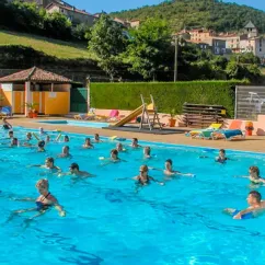 Camping La Cascade - groupe d'enfants dans l'eau de la piscine avec toboggan à côté