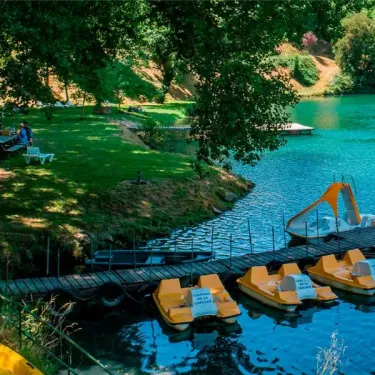 Camping La Cascade - lac avec vélos d'eau et embarcations au quai