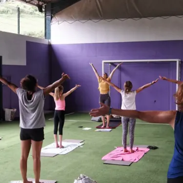 Groupes de personnes pratiquant le yoga dans une salle de camping Camping La Cascade