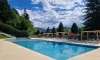 Piscine avec chaises longues et arbres autour au Camping Paradis Marmotel