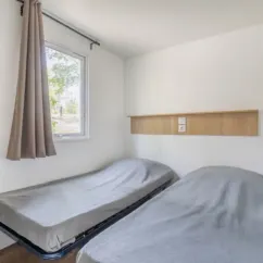 Chambre double avec lits superposés dans MH Confort+ 2CH – 4P - Camping Paradis Domaine de Gaujac