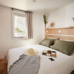 MH Confort+ 3CH – 6P - Camping Bel Air Village Le Brabois : chambre avec lit et décoration