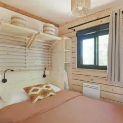Chambre avec lit double, étagères en bois et fenêtre - Cottage Premium 2CH - Camping Paradis Les Chanterelles