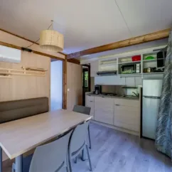 Cottage Premium 2CH – 5P (SAM) - Camping Paradis Le Coiroux, cuisine et salle à manger
