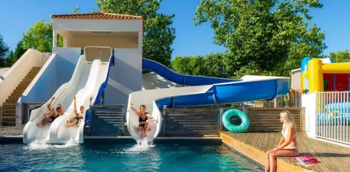 Camping Loyada - enfants glissant sur des toboggans aquatiques dans une piscine