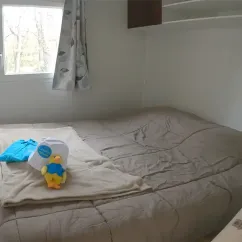 Lit dans le Mobil Home Pitchoun 2CH - 4P - Camping Paradis Le Ruou avec couverture et jouet