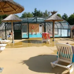 Piscine couverte avec chaises longues et visiteurs au Camping Les Hauts de Port Blanc