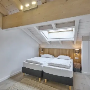 Chambre penthouse avec 2 lits, plafond en bois, fenêtre, lumières