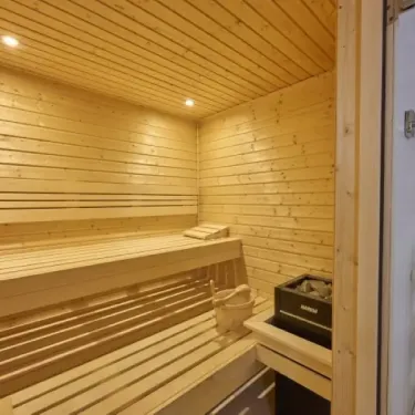 Penthouse avec Sauna 4CH - 8P - Parc AlpChalets Portes du Soleil : sauna en bois avec bancs et four à bois