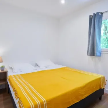 Chambre avec lit double et couvre-lit jaune dans Cigale 2CH - Village des Cigales