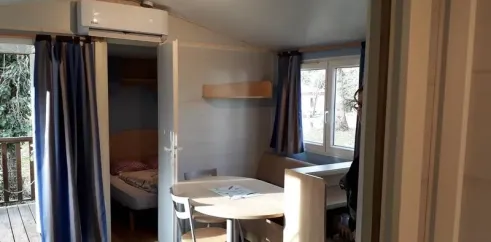Mobil Home Confort+ 2CH - 4P - Camping Vert Bord'Eau : salle à manger et lit