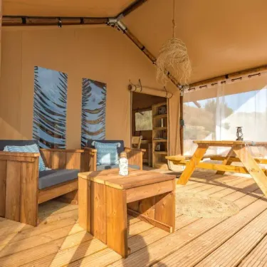 Intérieur du lodge avec canapé, table et table de pique-nique - Wood Lodge 2P, Camping Les Mizottes