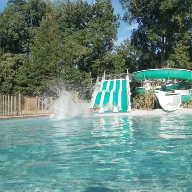 Glissière aquatique au Camping Le Valenty, enfant tombant dans la piscine