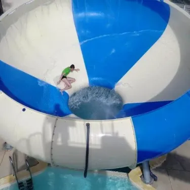 Enfant sur une chute d'eau en forme de sphère au Camping Cap Agathois