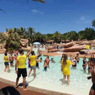 Les Sables d'Or Pirates World : enfants dans une piscine avec cascade, surveillants en jaune.