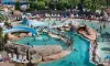 Piscine aquatique avec toboggan et chaises longues au Camping Les Sables d'Or Pirates World