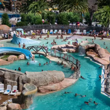 Piscine aquatique avec toboggan et chaises longues au Camping Les Sables d'Or Pirates World