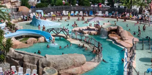 Piscine aquatique avec toboggan et chaises longues au Camping Les Sables d'Or Pirates World