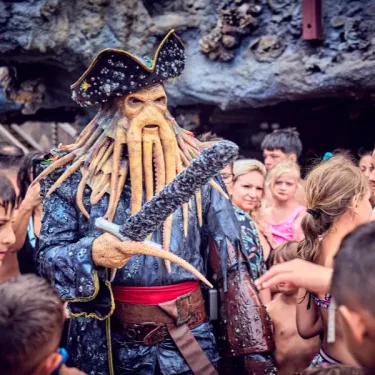 Personnage de pirate en costume devant un groupe d'enfants à Camping Les Sables d'Or