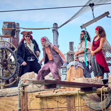 Les Sables d'Or Pirates World : personnages en tenue de pirates sur un bateau en bois.