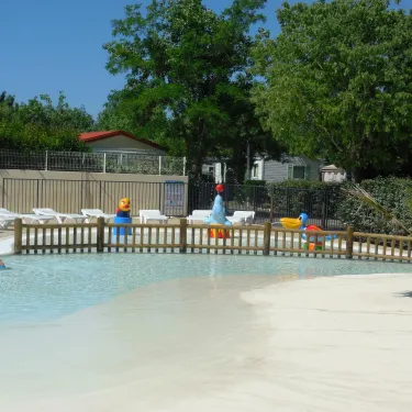 Piscine pour enfants avec jouets flottants, chaises longues et palmier - Camping Cap Agathois