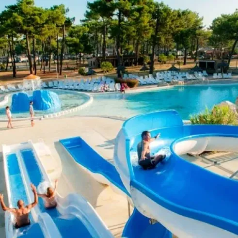 Camping Atlantique Club Montalivet - piscine avec toboggan et personnes se détendant autour